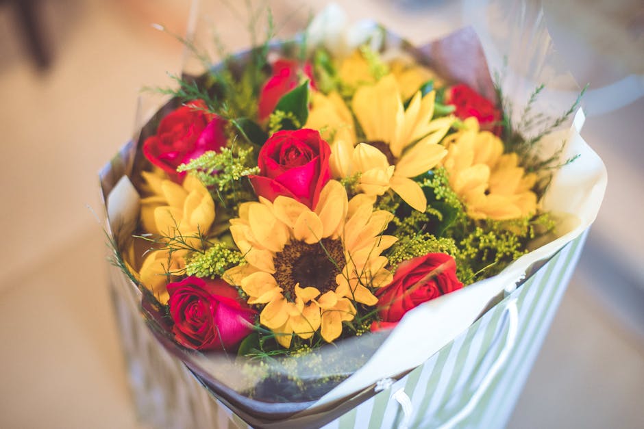 A vibrant bouquet of fresh flowers delivered by flowerdeliverycamberley.co.uk, featuring bright yellow sunflowers with large dark centers, surrounded by elegant pink roses with tightly packed petals, 